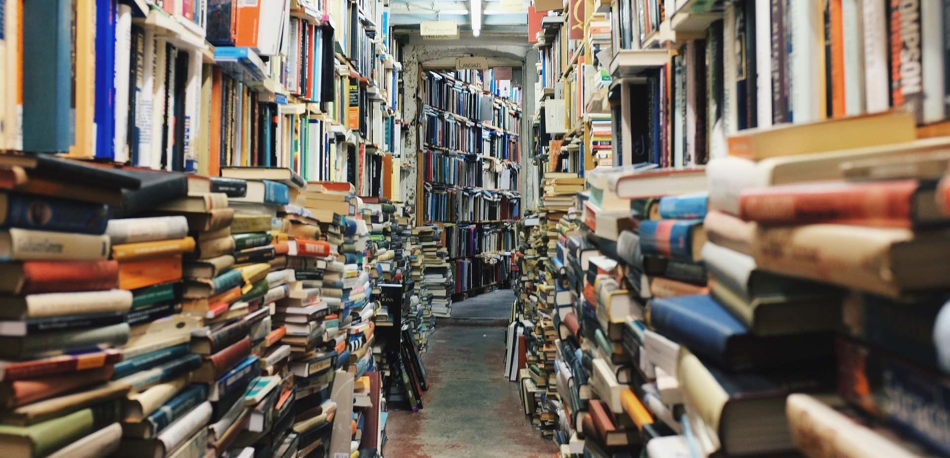 Catasta di libri in biblioteca: infermiera, psicoterapeuta e informatico